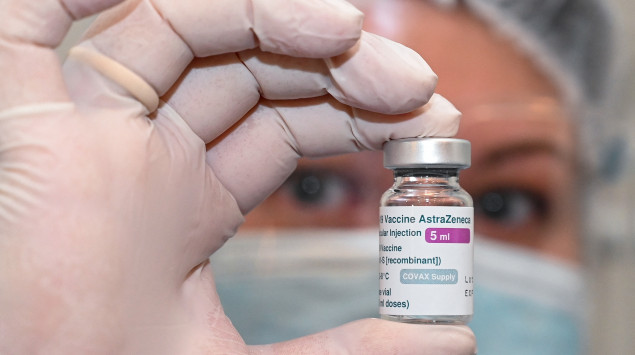 Eine Krankenhausangestellte hält ein Fläschchen mit AstraZeneca-Impfstoff in die Höhe