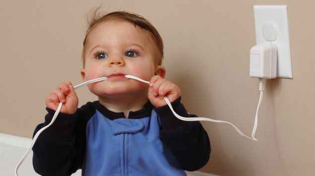 Ein Baby kaut auf einem Stromkabel.