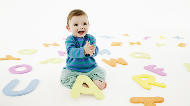 Ein Baby spielt mit Spielzeug-Buchstaben