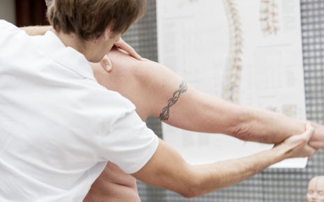 Arthrose: Ein Arzt testet, wie weit der Arm eines Mannes bewegbar ist.