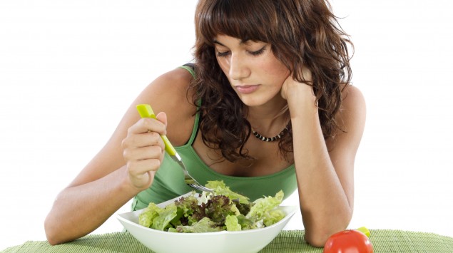 Das Bild zeigt eine Frau, die im Essen stochert.