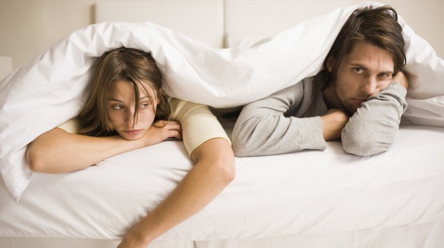 Das Bild zeigt ein frustriertes Paar im Bett.