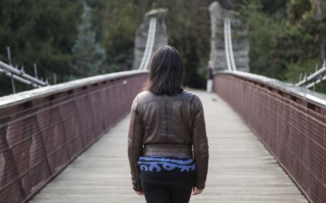 Eine Frau geht über eine Brücke.