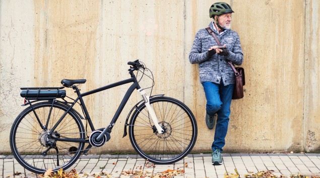 Ein älterer Mann neben einem E-Bike: Wer erstmals aufs Elektrofahrrad steigen möchte, sollte ein paar Tipps beachten.