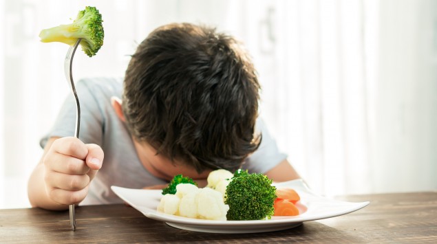 Ein Junge mag sein Gemüse nicht essen.