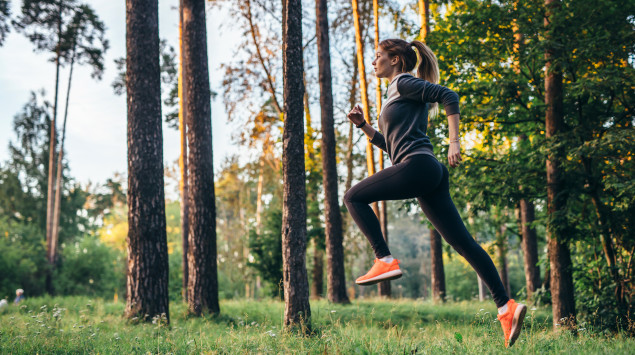 Eine Frau joggt (läuft) im Wald.