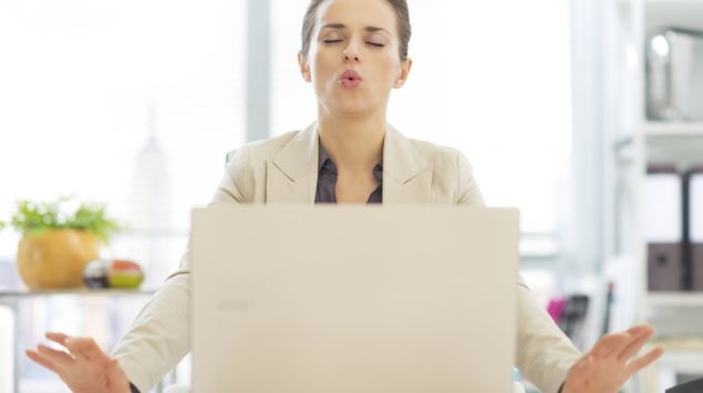 Das Bild zeigt eine junge Frau, die vor ihrem Laptop sitzt und ihre Finger abspreizt.