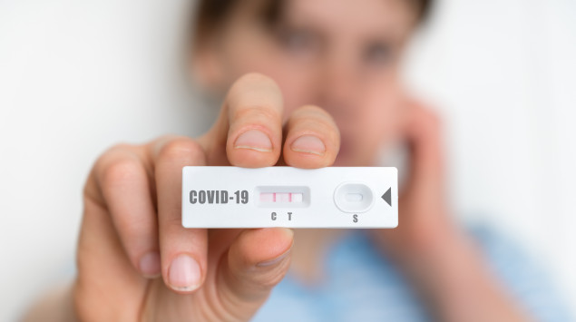 Eine Frau hält einen positiven Corona-Test in die Kamera