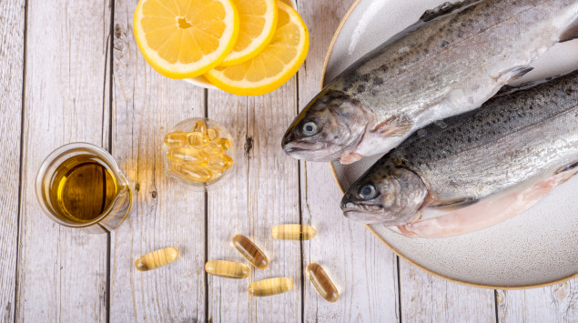 Das Bild zeigt Lebertran-Tabletten, Fisch und Zitrone.