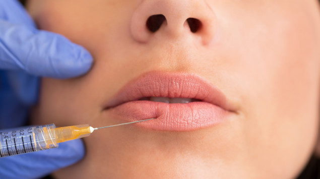 Eine Frau lässt sich die Lippen aufspritzen/eine Lippenkorrektur durchführen.