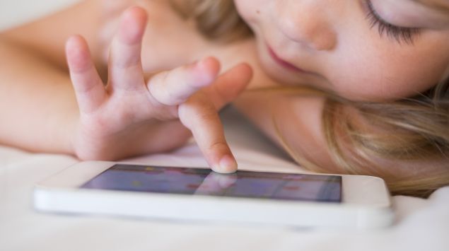 Ein kleines Mädchen spielt auf dem Smartphone.