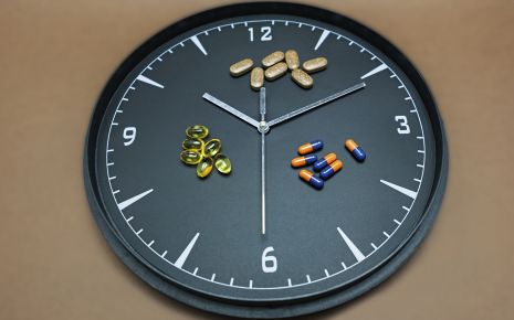 Man sieht eine Uhr und verschiedene Medikamente.