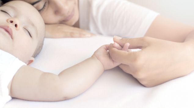 Eine Frau hält die Hand eines Babys.
