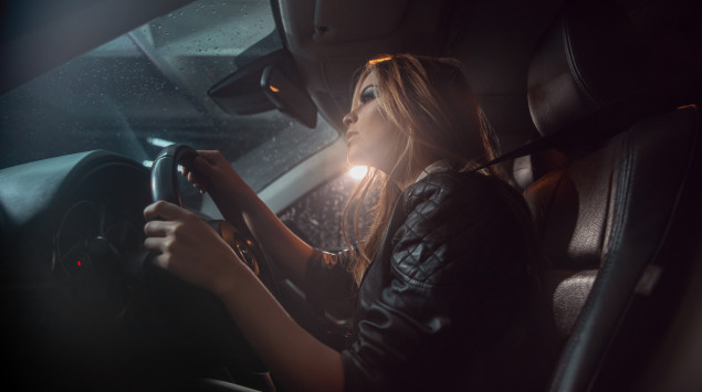 Eine Frau fährt nachts sehr vorsichtig auto