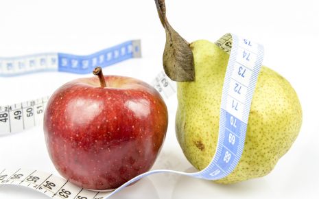 Ein Apfel, eine Birne und ein Maßband.