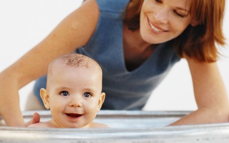 Eine Mutter badet ihr Baby.