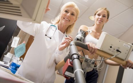 Das Bild zeigt eine junge Frau, die auf einem Laufband eine EKG-Untersuchung
