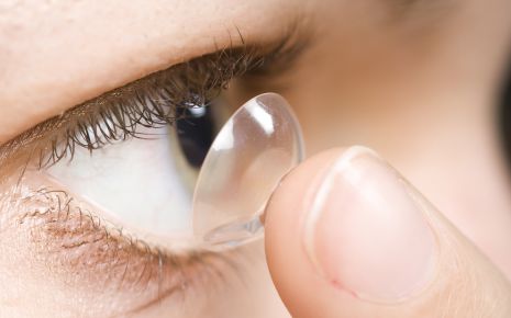 Eine Frau setzt sich eine weiche Kontaktlinse ein.