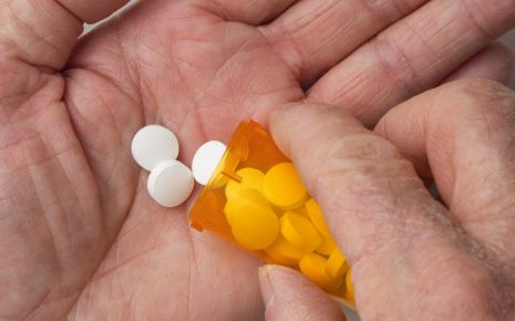 Jemand hält ein Röhrchen mit Tabletten in der Hand.