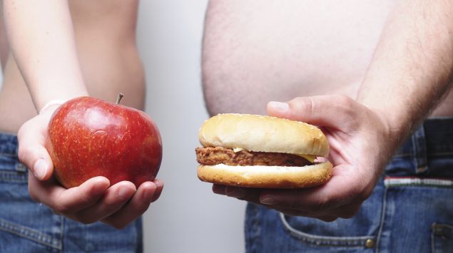 Das Bidl zeigt eine Frau, die einen Apfel hält und einen Mann, der einen Burger hält.