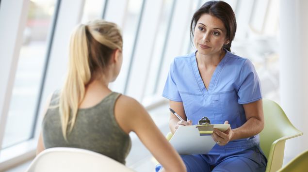 Das Bild zeigt eine Frau im Gespräch mit einer Ärztin.