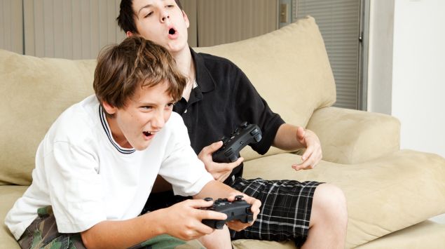 Zwei männliche Teenager spielen ein Computerspiel.