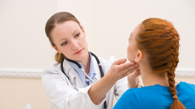 Das Bild zeigt eine Ärztin, die den Hals einer Patientin abtastet.
