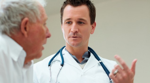 Das Bild zeigt ein Gespräch zwischen einem älteren Patienten und einem Arzt.