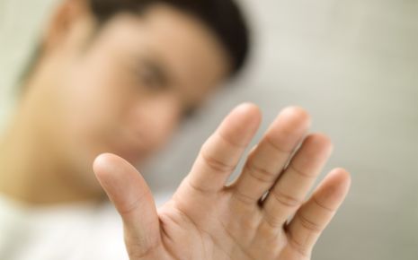Ein Mann macht mit der Hand eine abwehrende Geste.