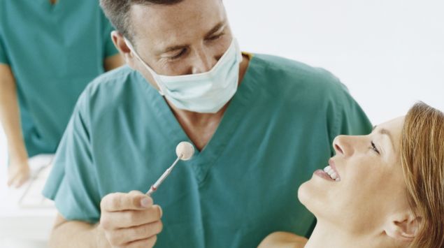 Das Bild zeigt eine Patientin und einen Zahnarzt.
