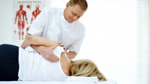 Ein Orthopäde / Osteopath behandelt eine Patientin.