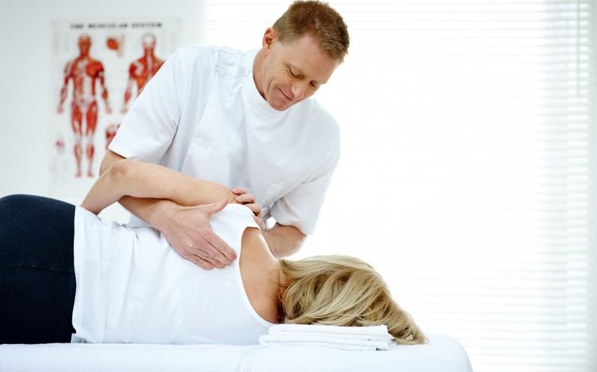 EIn Therapeut behandelt eine Patientin.