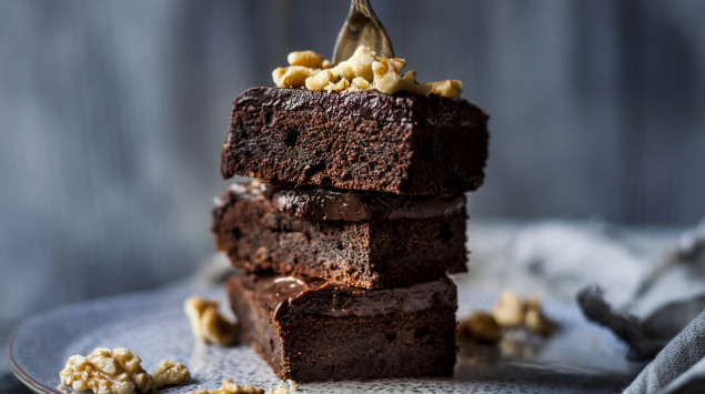 Drei Schoko-Brownies auf einem Teller mit Walnüssen.