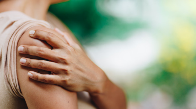 Ein Physiotherapeut behandelt die Schulter einer Patientin.