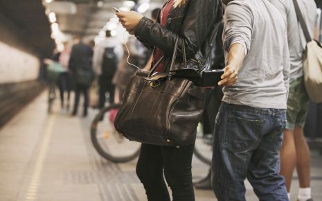Jemand stiehlt einer jungen Frau an der U-Bahn-Station etwas aus der Handtasche.