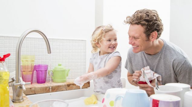 Ein Vater wäscht mit seiner kleinen Tochter ab.