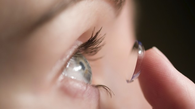 Eine Fraue setzt eine weiche Kontaktlinse ein.